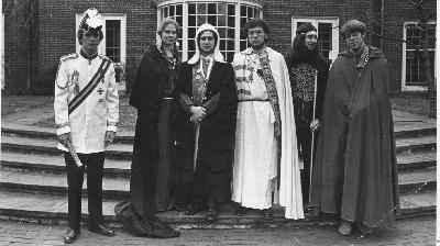 Black and white photo of Councillors-General standing in front of a set of steps and, in the background a brick building with a bay window.